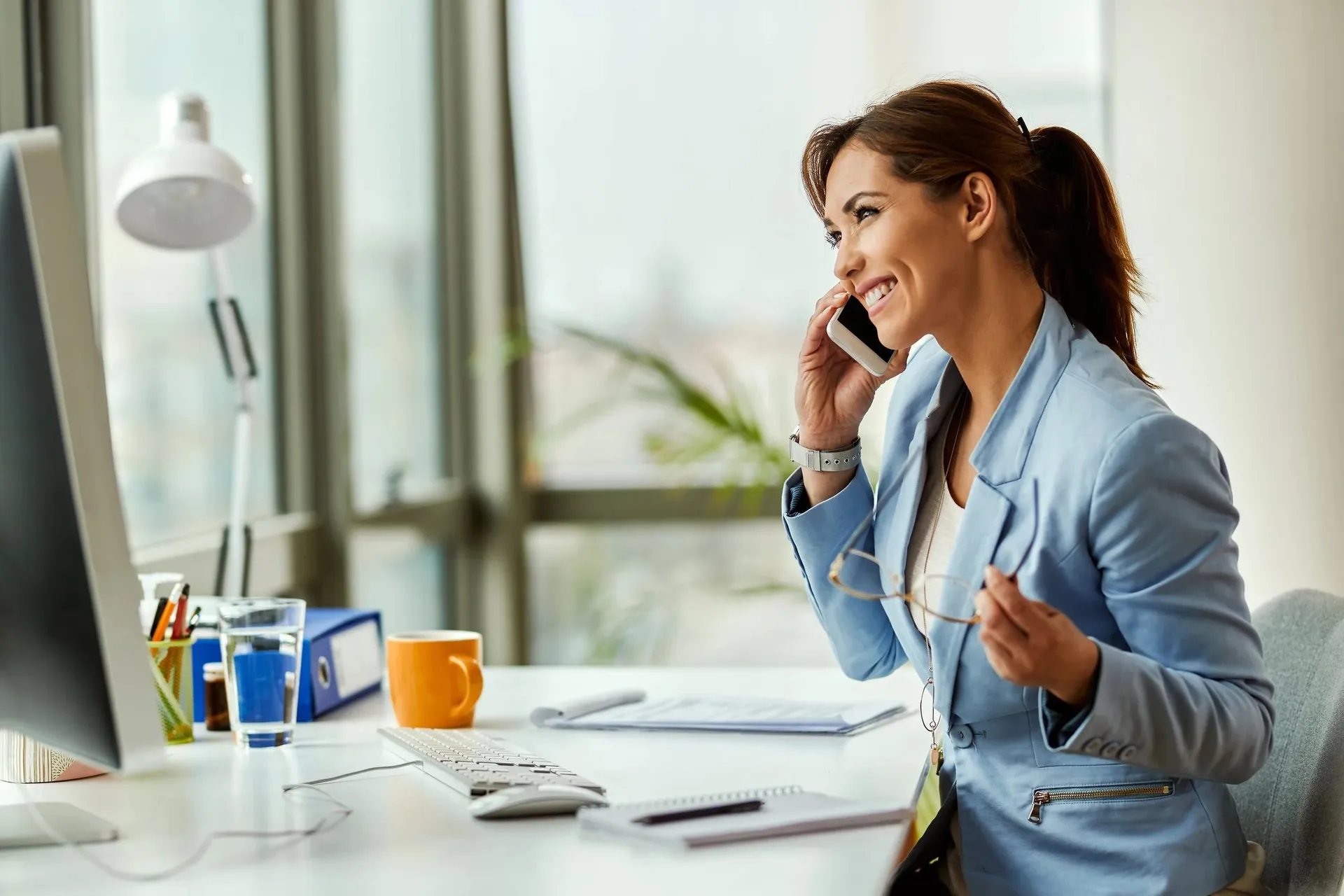 A businesswoman speaking on the phone at her desk